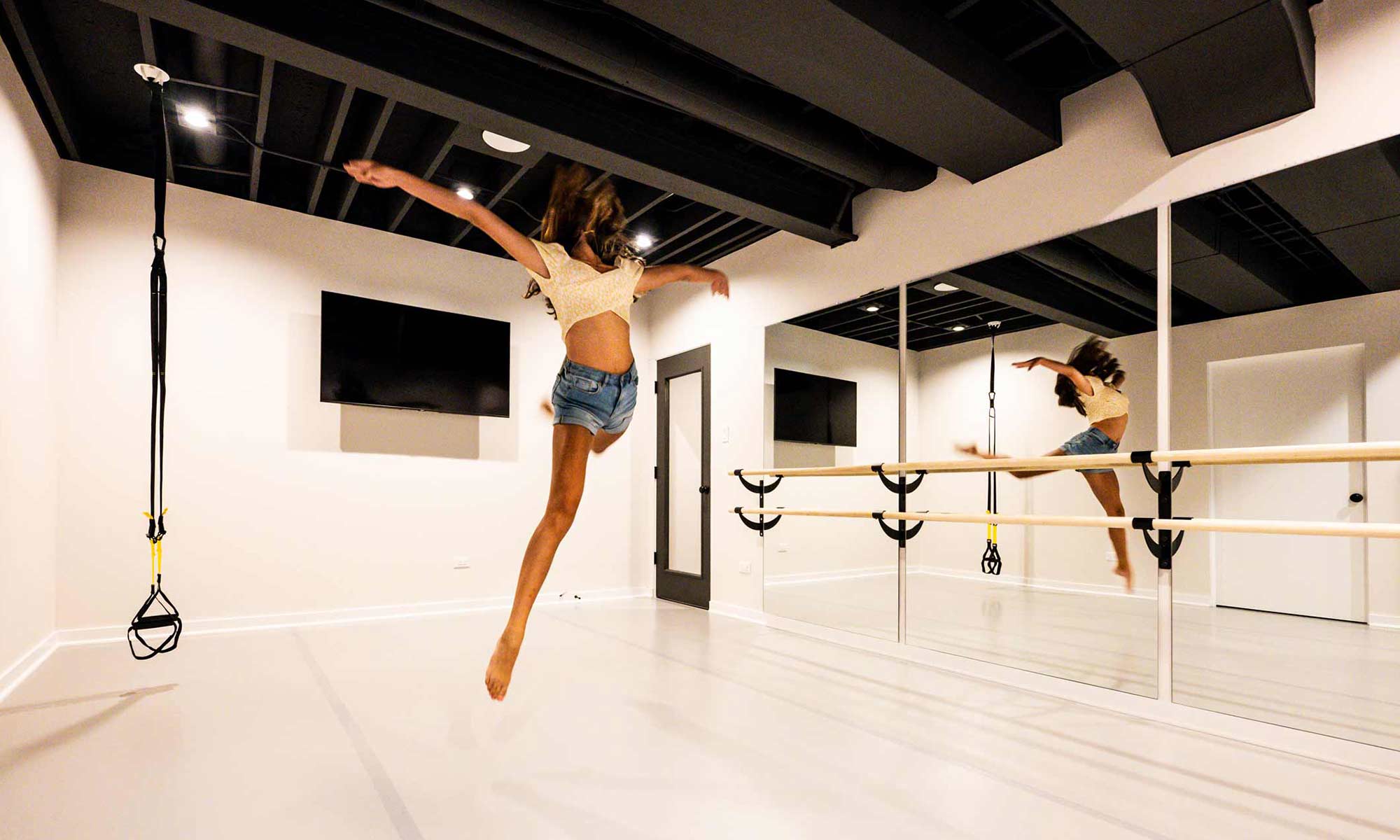 girl doing jump in home dance studio