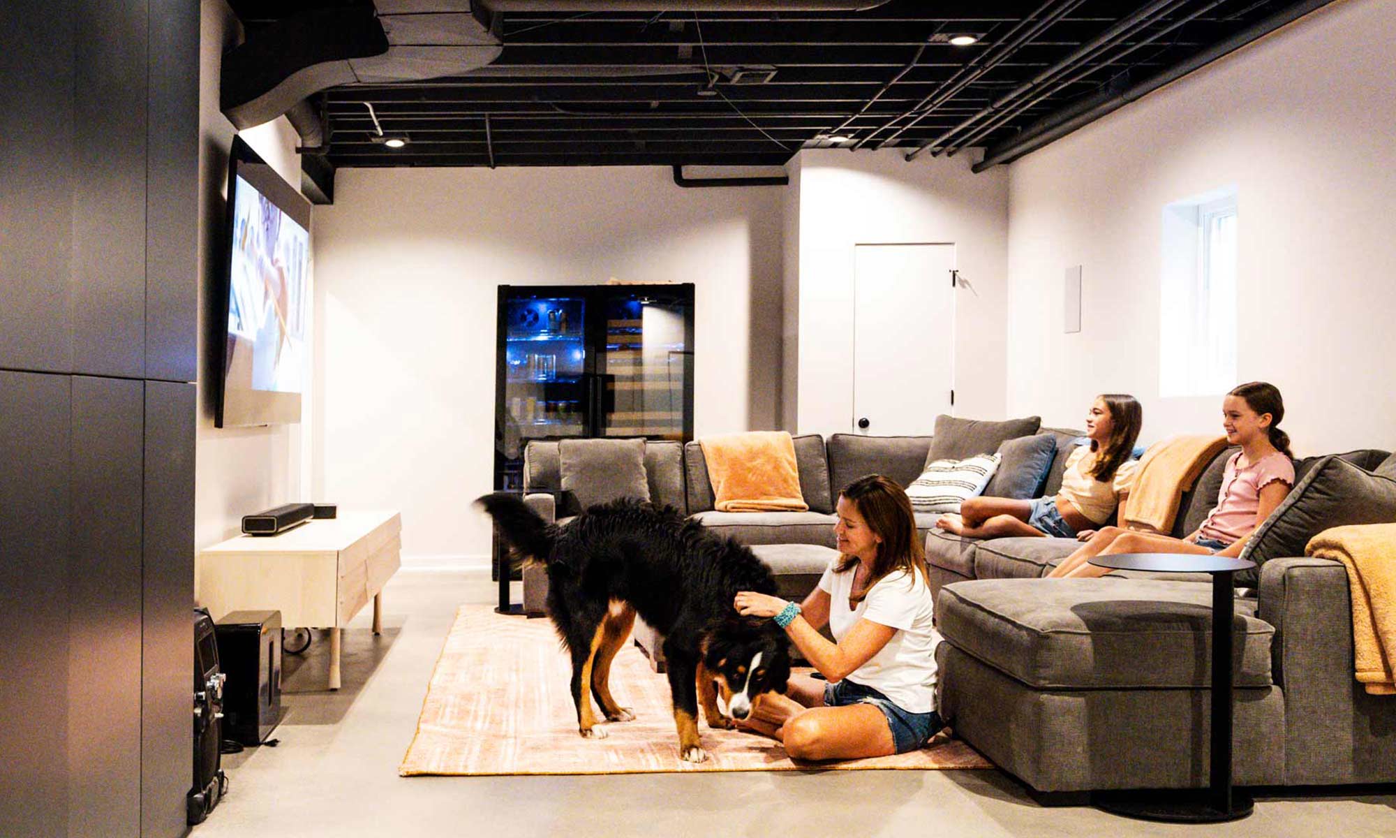 family gathered with bernese dog in basement recreation room