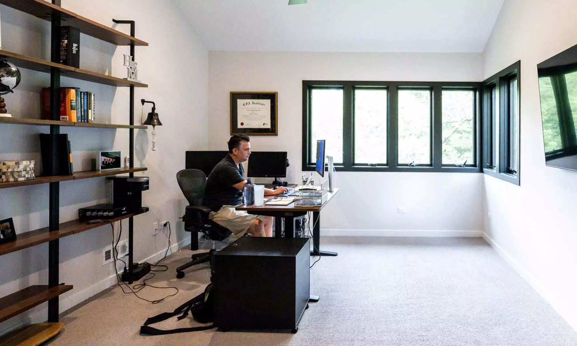 interior view of modern shelves and desk in home office addition with man working