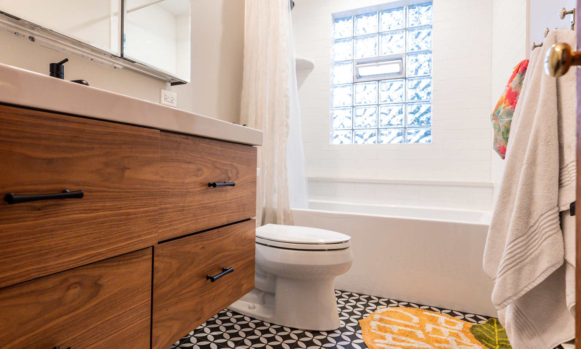 view of remodeled MCM bathroom with black and White floor tile