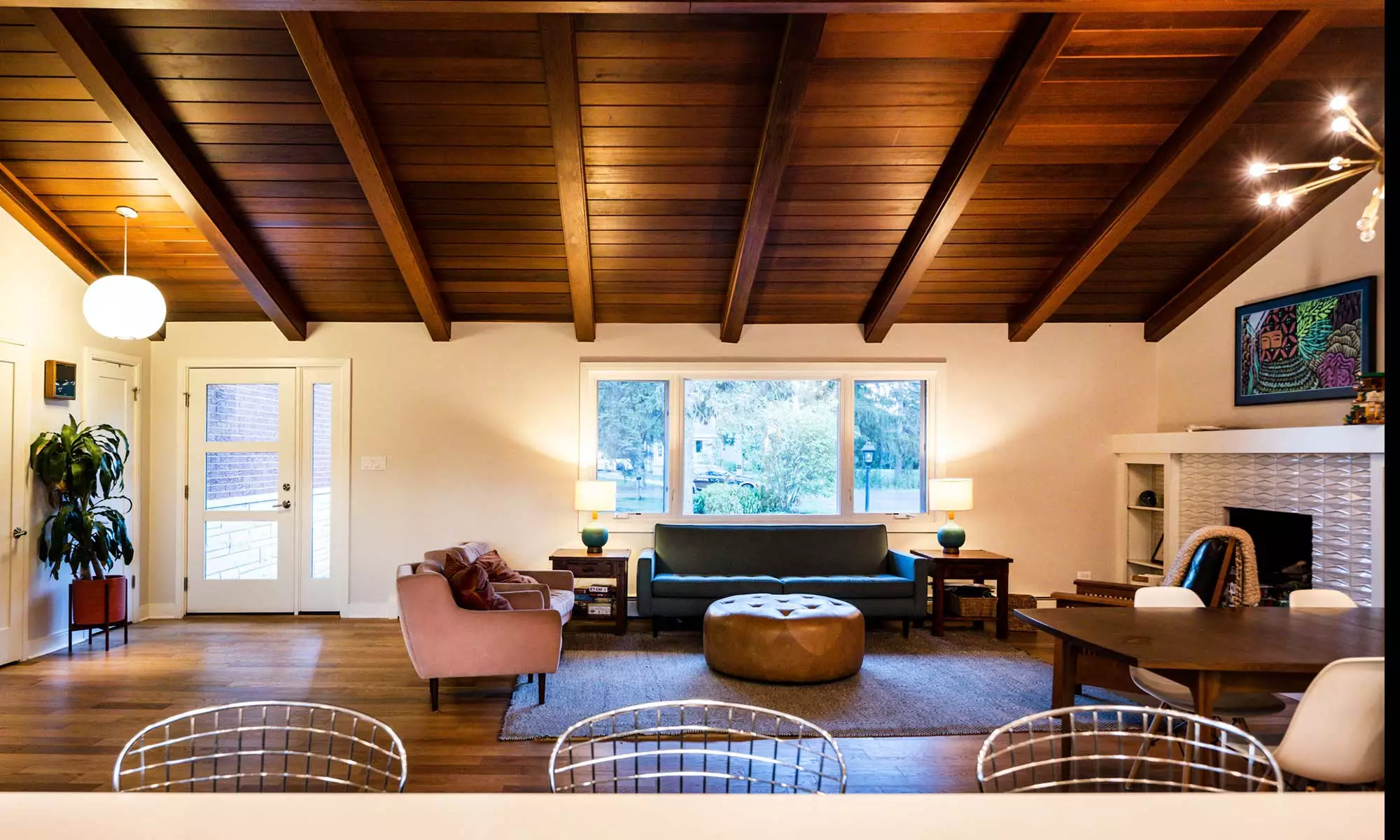 view of modern living room with vaulted wood ceilings and MCM front door