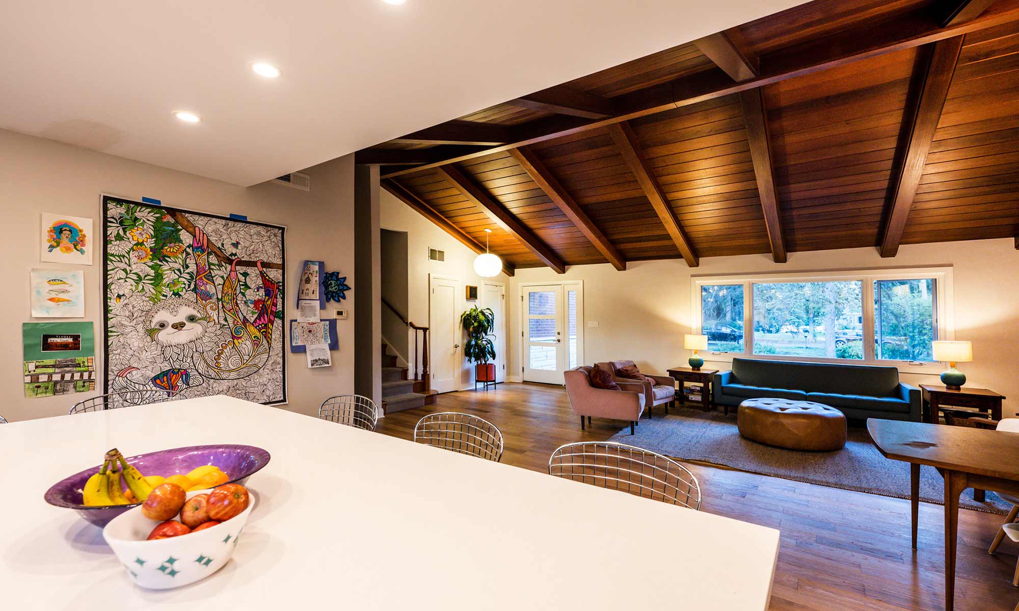 view of modern living room with vaulted wood ceilings and MCM front door