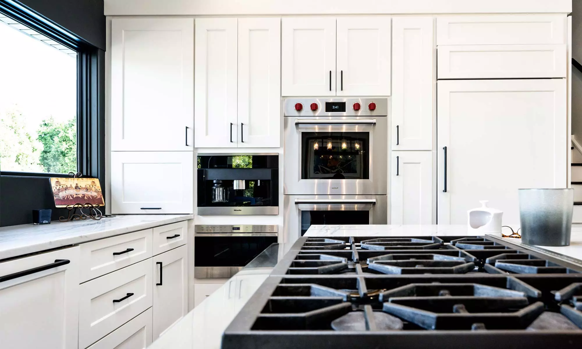 luxury kitchen view with white cabinets builtin appliances and island range