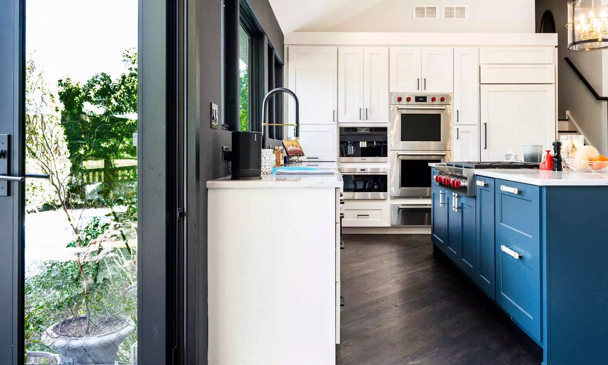 luxury kitchen remodel with blue island and windows to the backyard pool