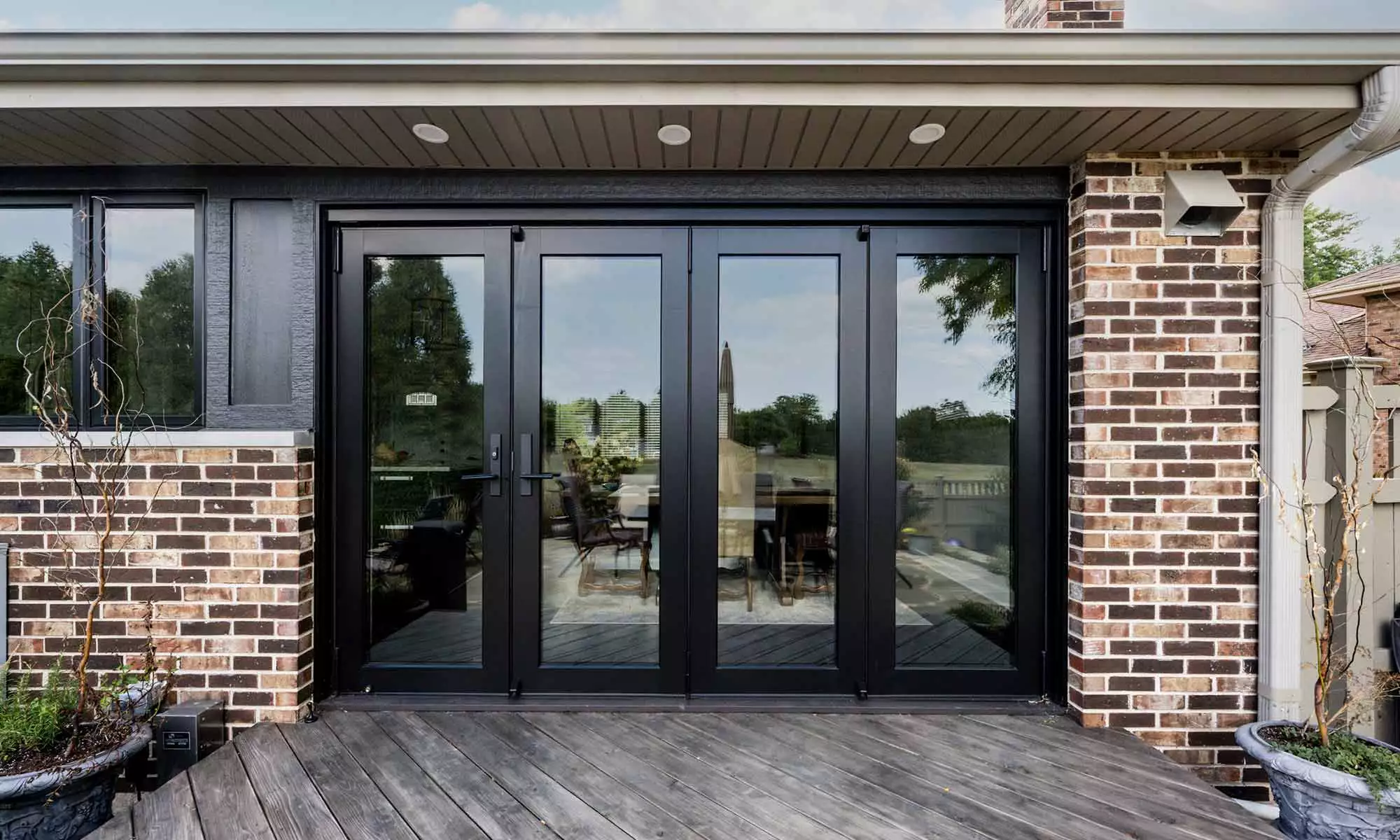 exterior view of remoeled home with brick and glass and folding glass door