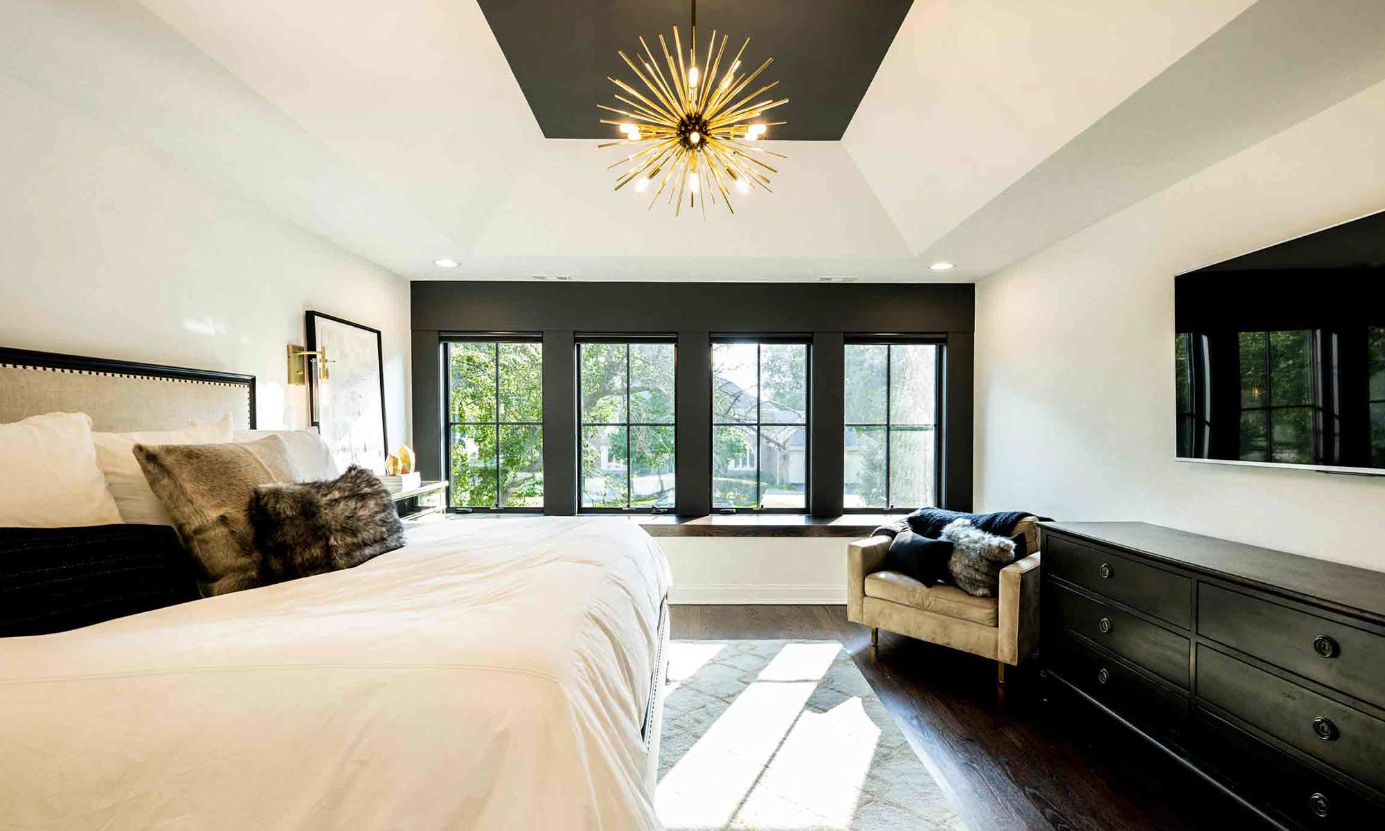 primary suite addition with dark tray ceilings and four windows