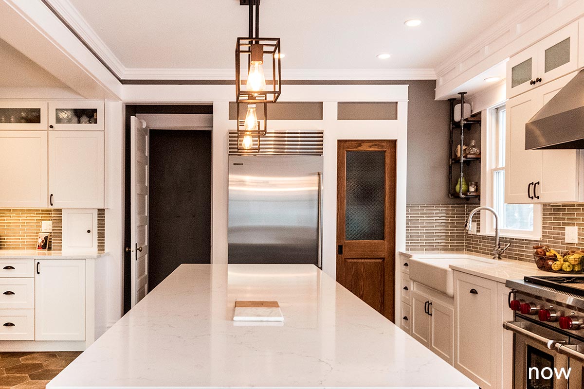 liv companies kitchen reovation three light fixtures over large white granite island