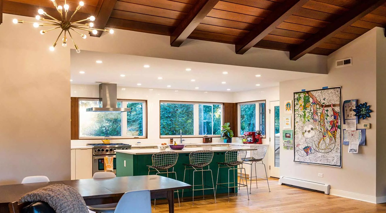 home renovation exposed beams in living room recess lighting in kitchen large green island