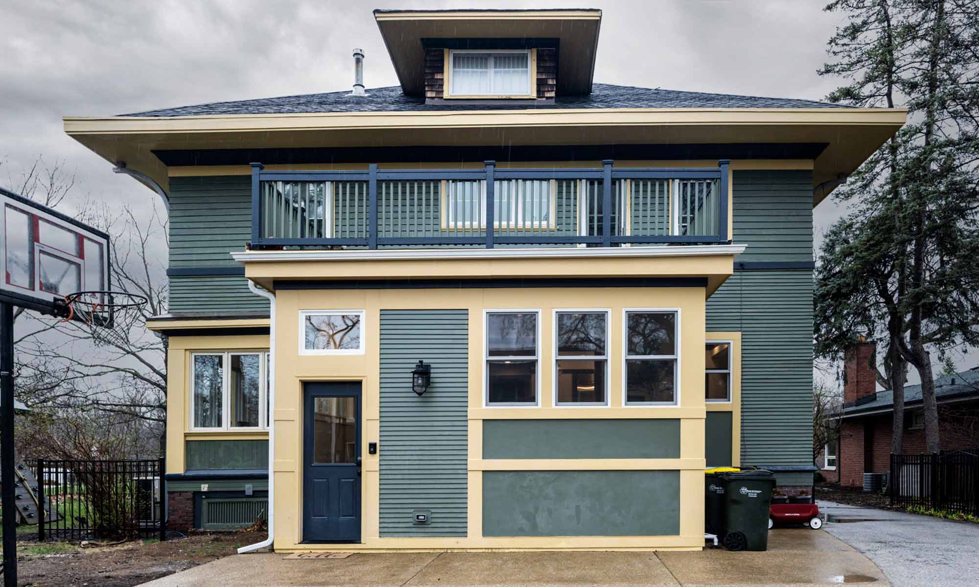 exterior view of mudroom addition with green siding and dark yellow trim