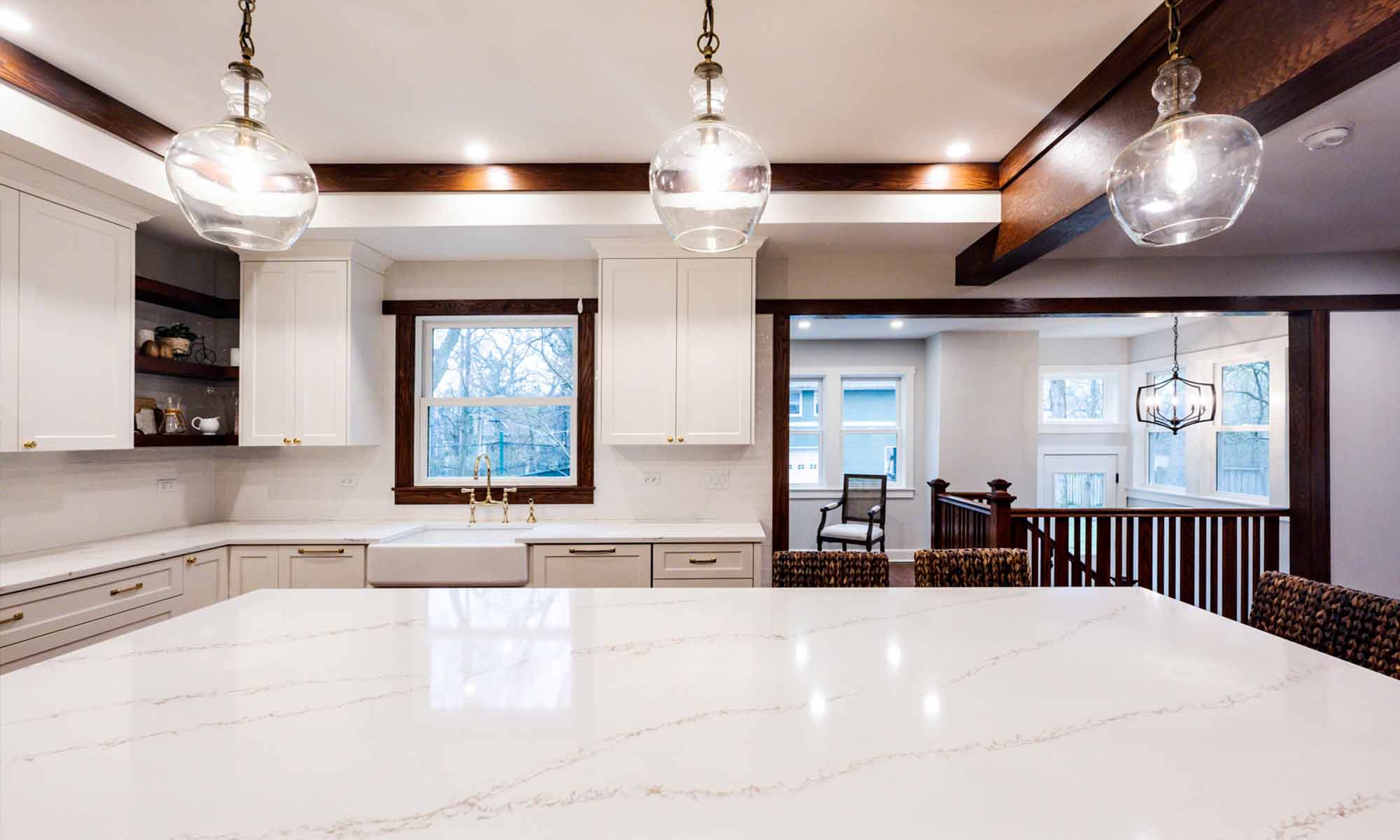 interior view of white kitchen cabinets and quartz island countertop