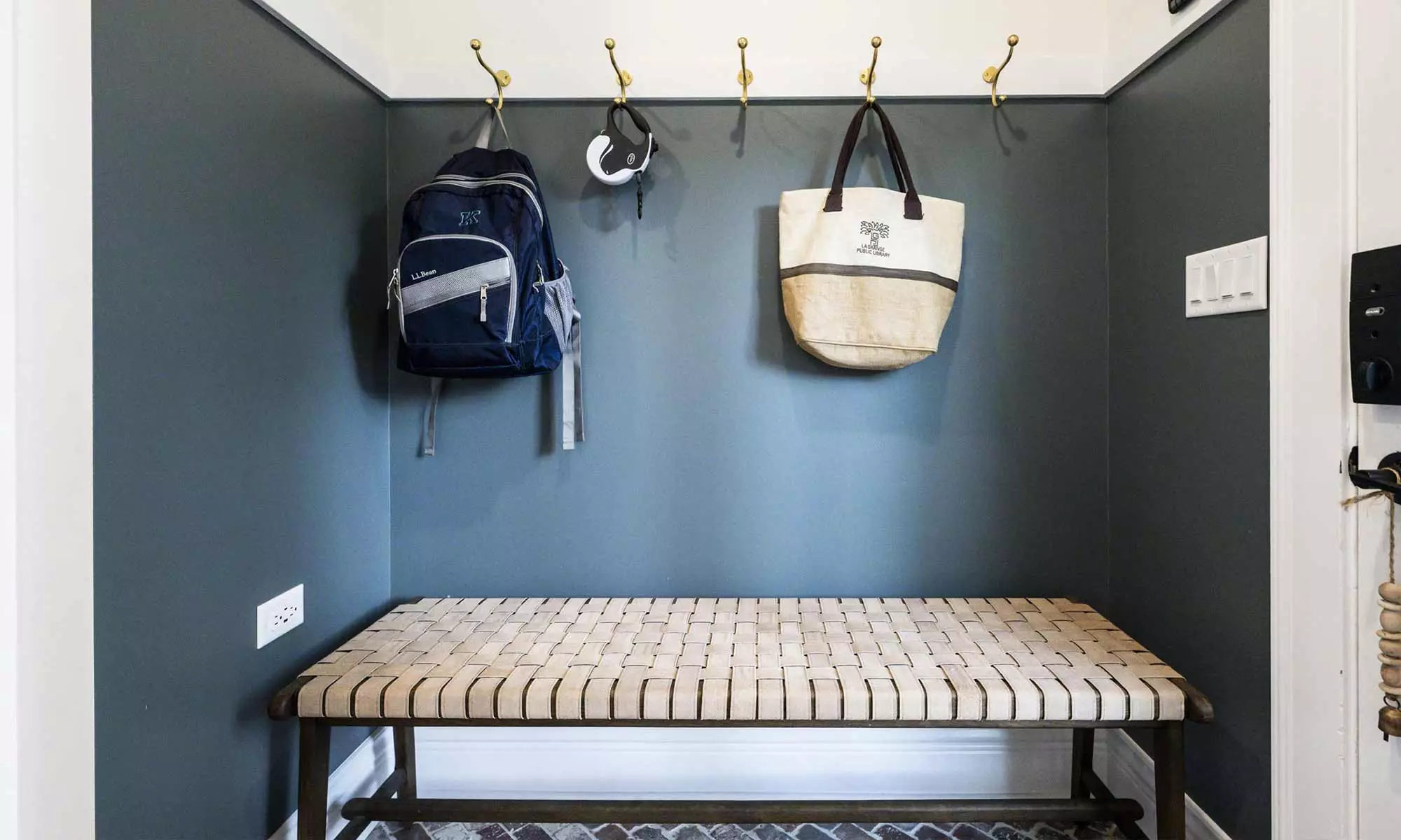 mudroom remodel with hanging bags and thatch bench