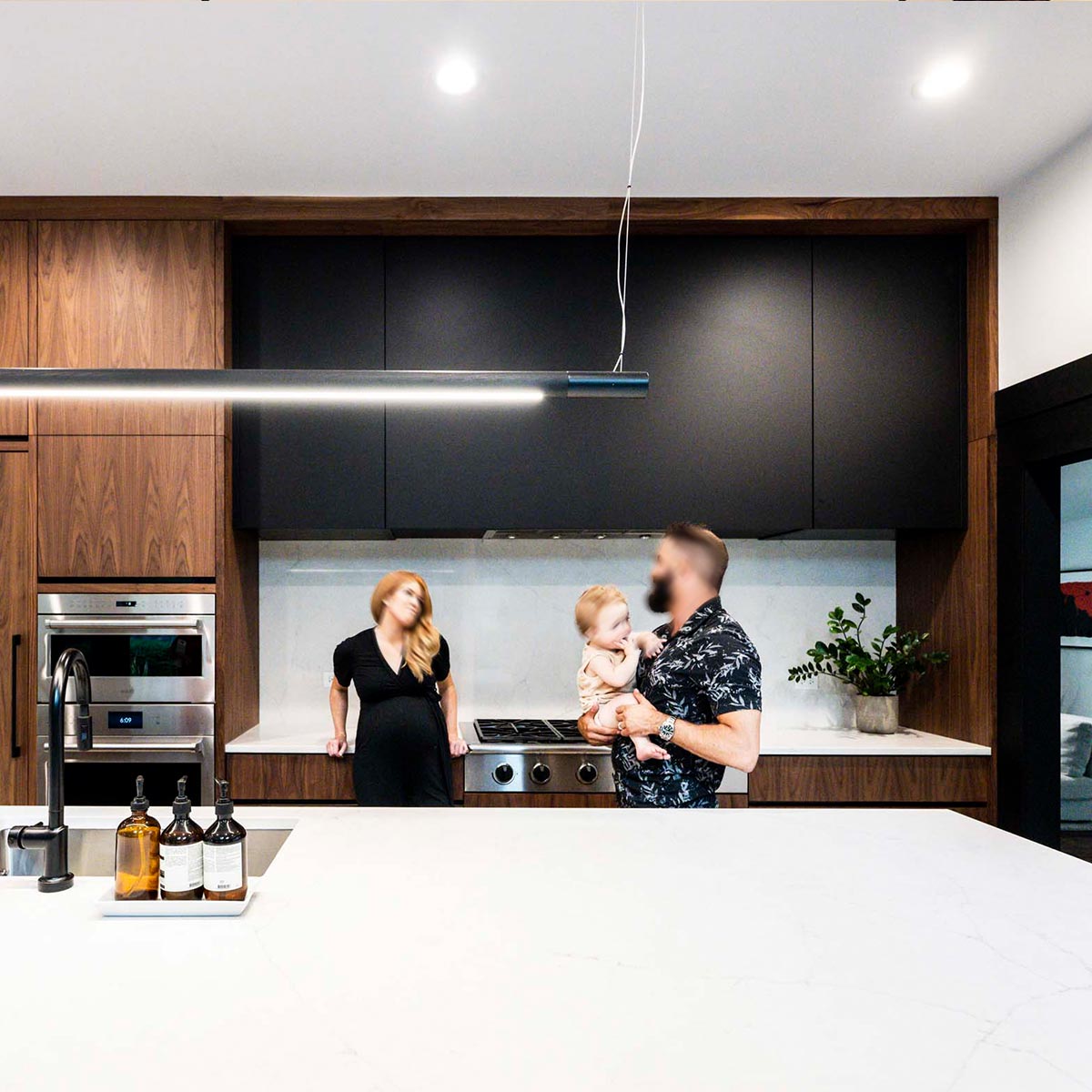 Couple standing in their updated Modern Hinsdale kitchen while husband holds toddler