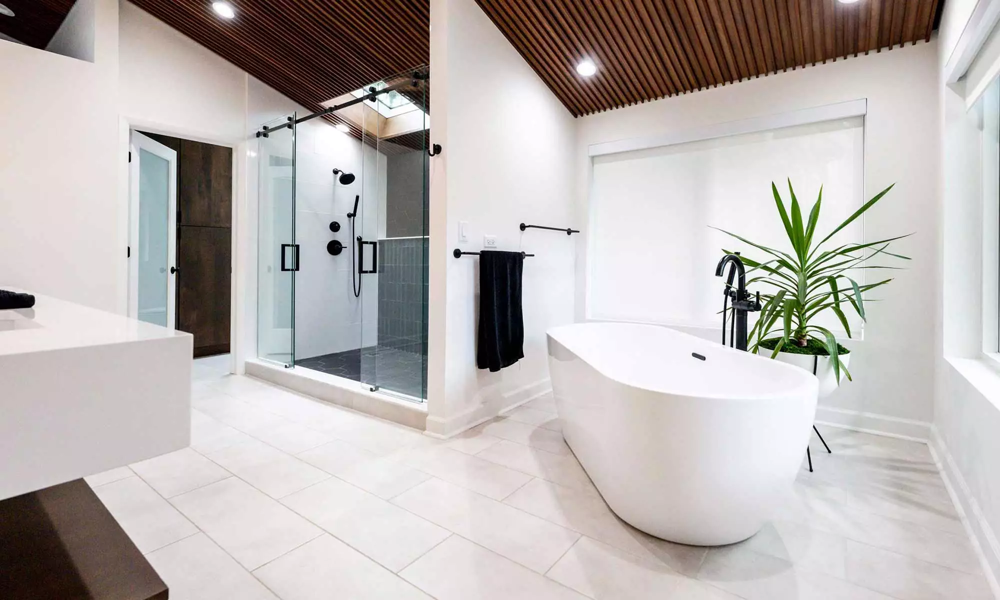 luxury California style modern bathroom remodel by LivCo in Hinsdale Illinois with wood ceiling and freestanding tub