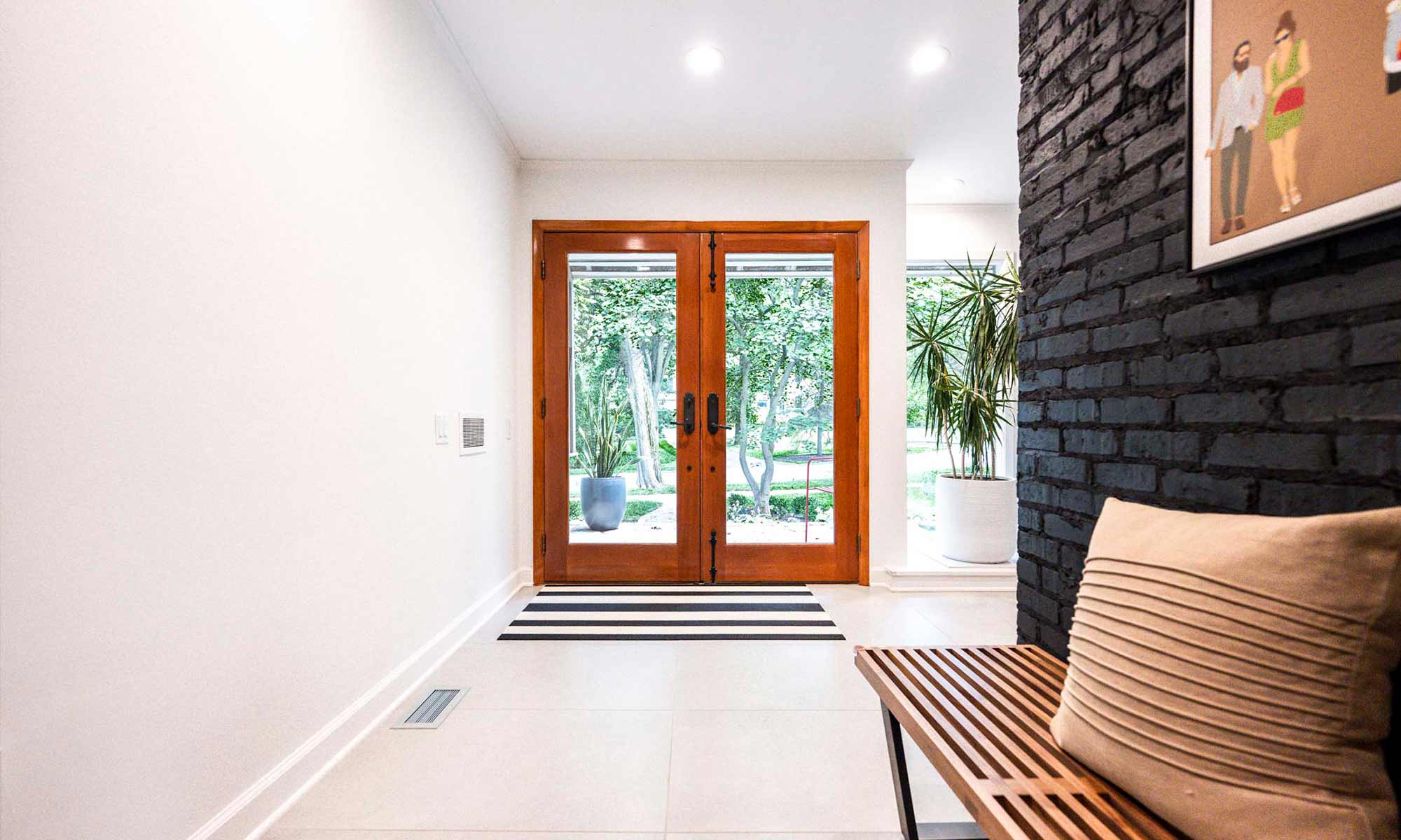 modern entryway in mcm remodel with glass double entry doors in wood