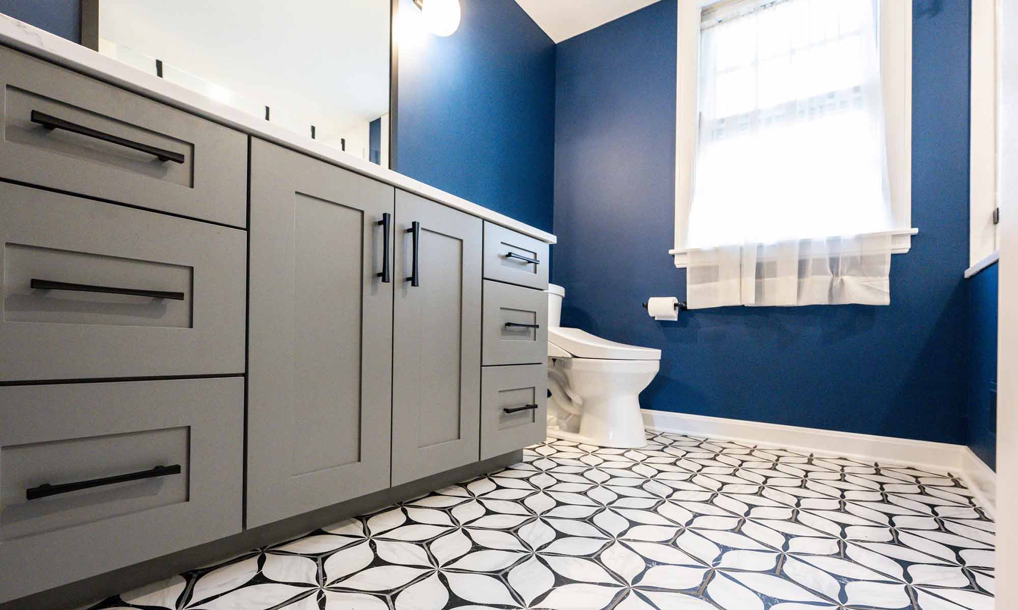 luxury bathroom remodel with grey cabinets and blue walls