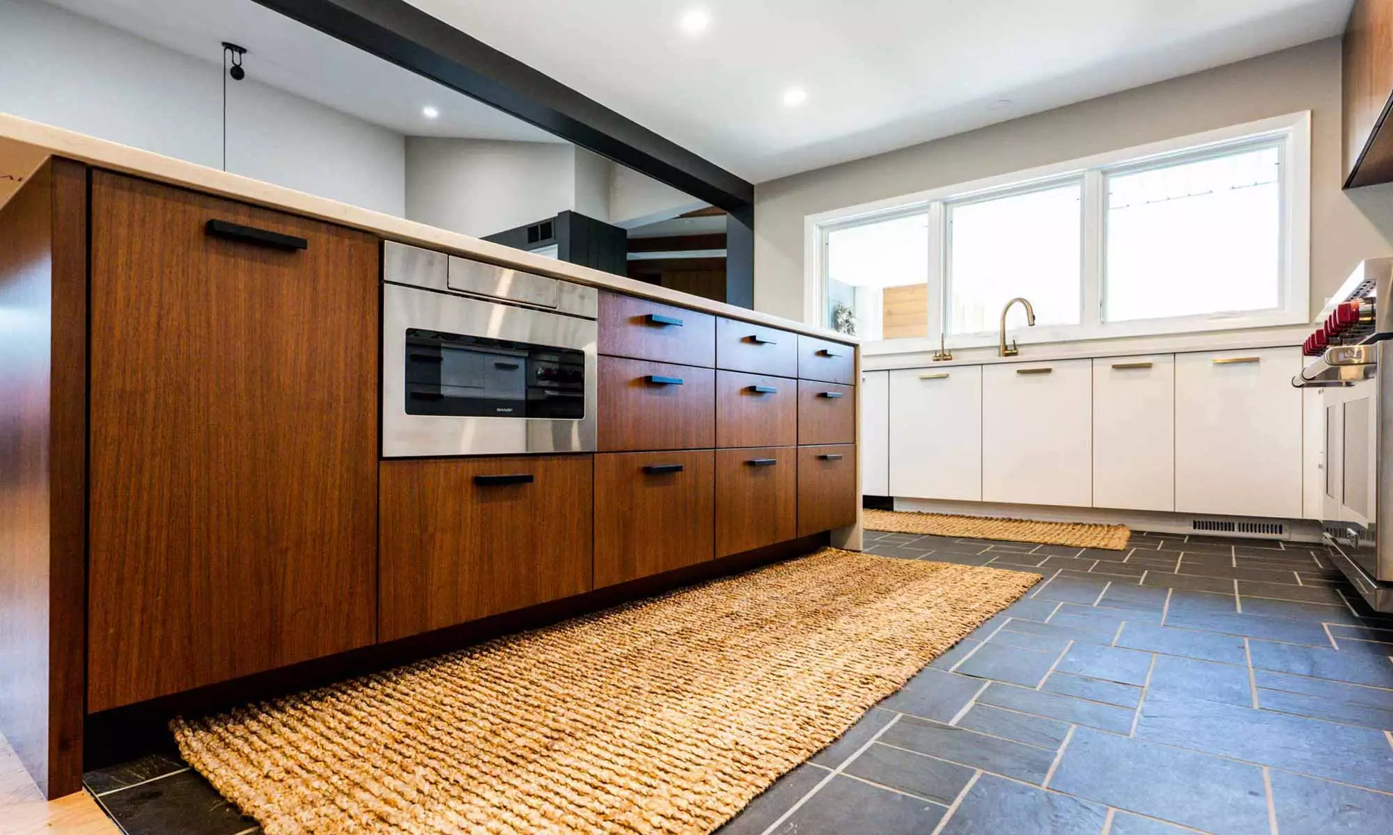 view of walnut island with slate floors in luxury mid century remodeled kitchen