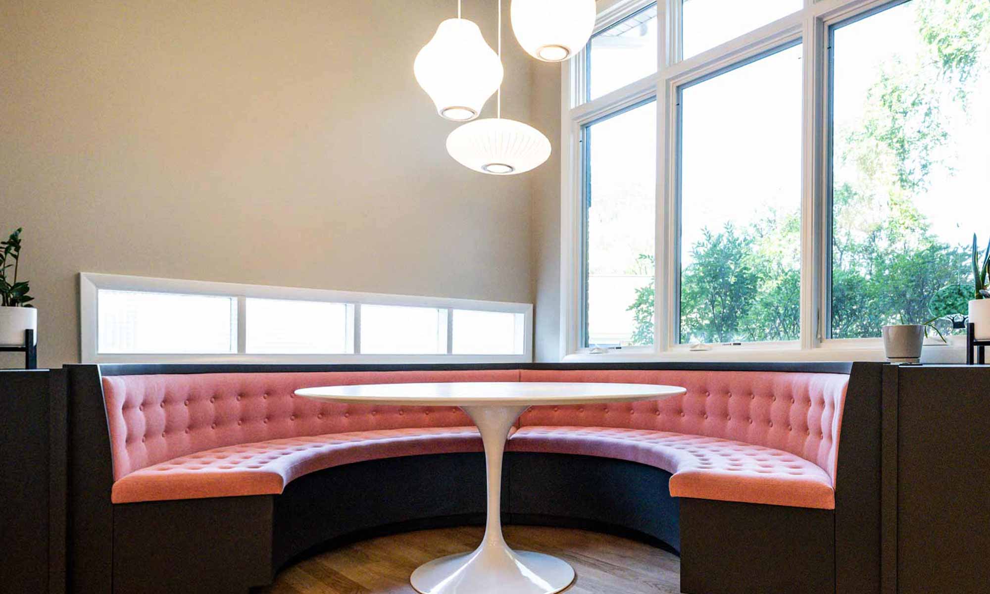 pink upholstered round corner booth seating in mid century luxury remodel