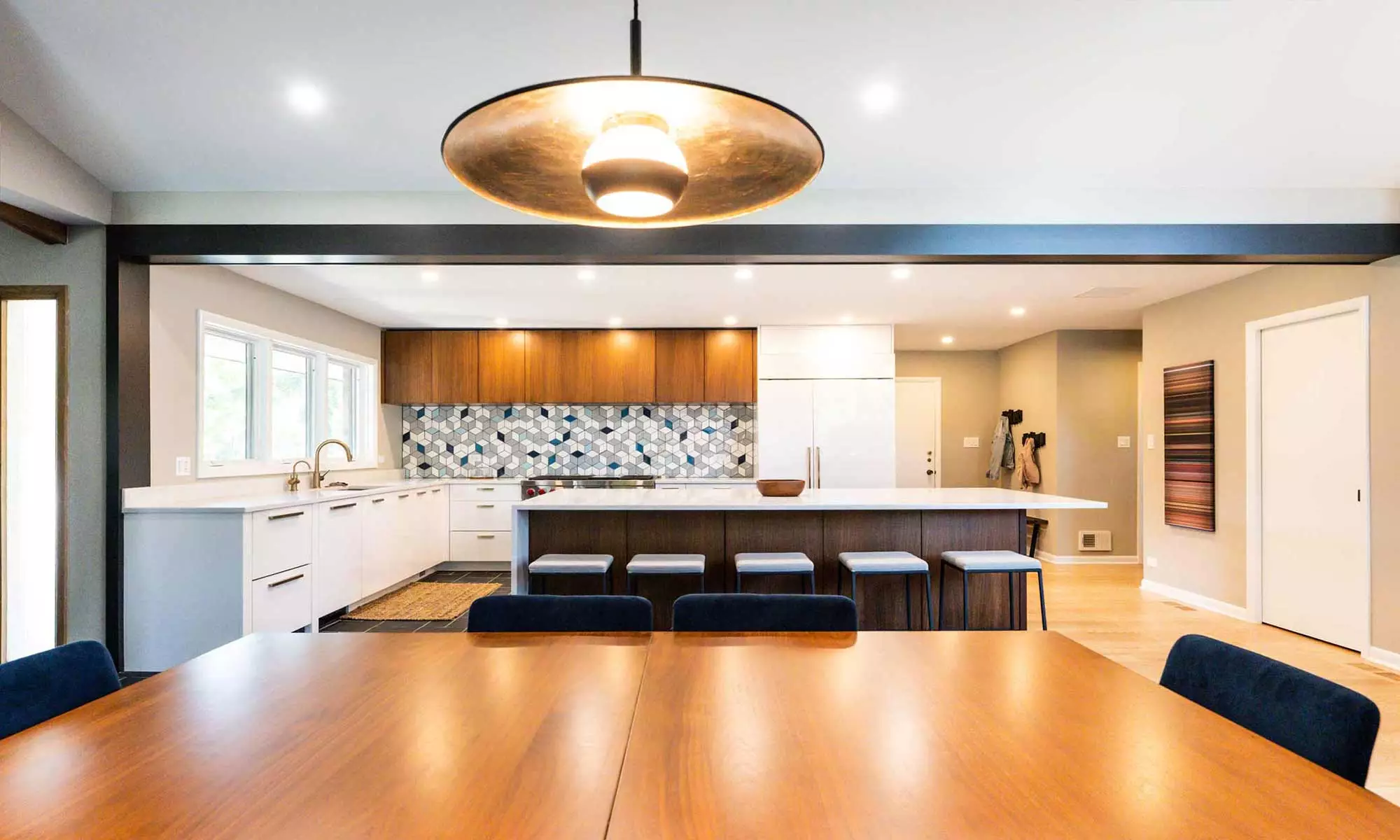 view of dining area with pendant light and kitchen beyond in luxury mid-century remodel