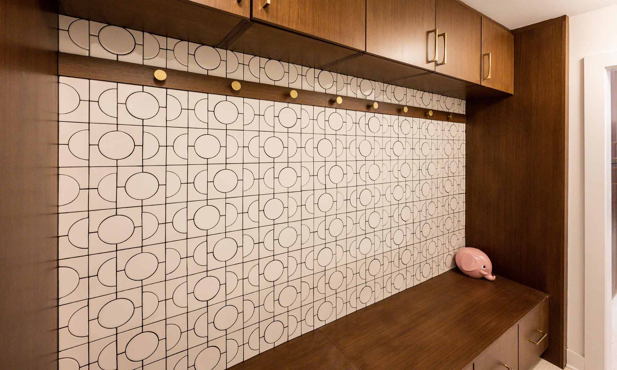 builtin walnut mudroom cabinets with geometric mcm tile in mid century modern mudroom remodel in Riverside IL designed and built by LivCo