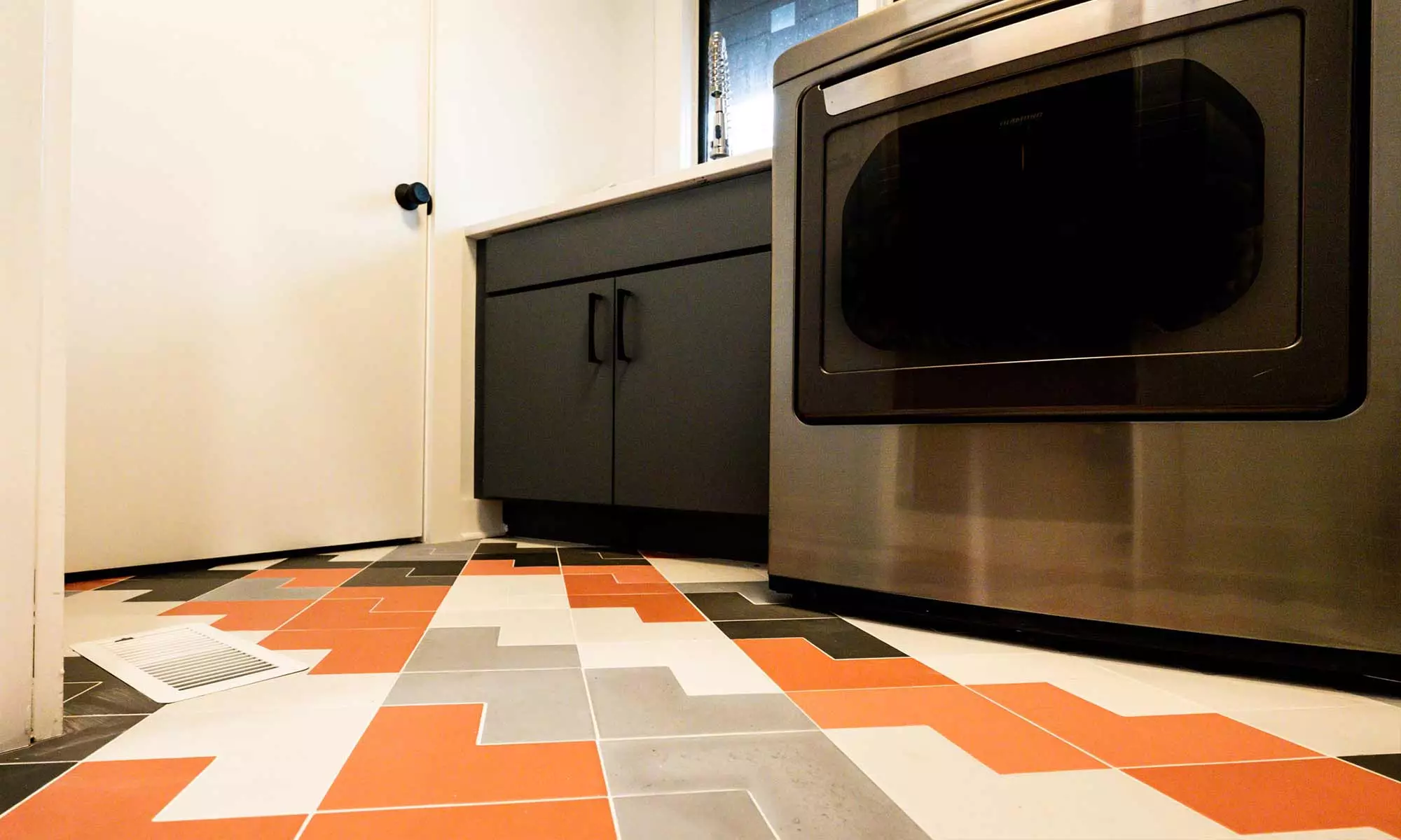 textured laundry room tile in grey orange black and white