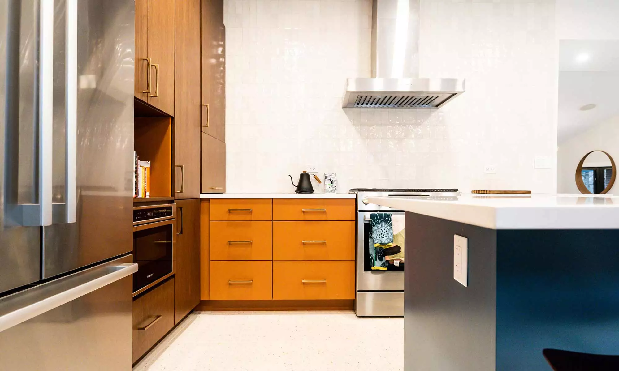 Mid century modern luxury kitchen remodel in Riverside IL by LivCo with blue island orange perimeter cabinets walnut tall cabinets and terrazzo flooring