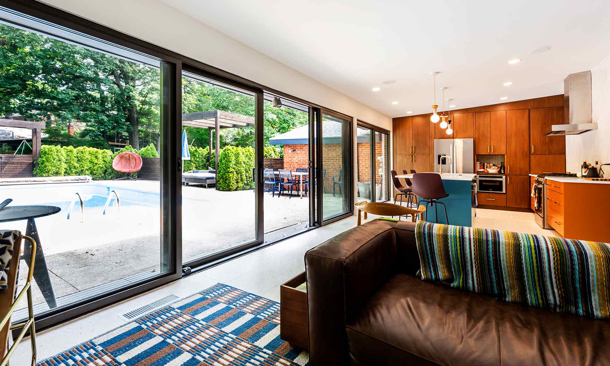 Mid century modern luxury kitchen remodel in Riverside IL by LivCo with blue island orange perimeter cabinets walnut tall cabinets and terrazzo flooring