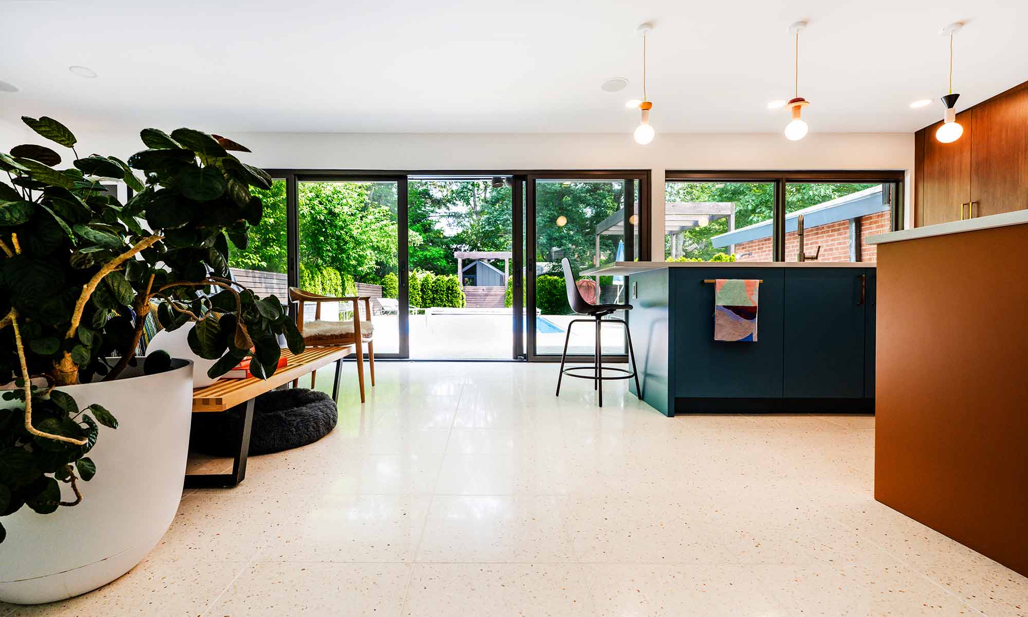 Mid century modern luxury kitchen remodel in Riverside IL by LivCo with blue island orange perimeter cabinets walnut tall cabinets and terrazzo flooring