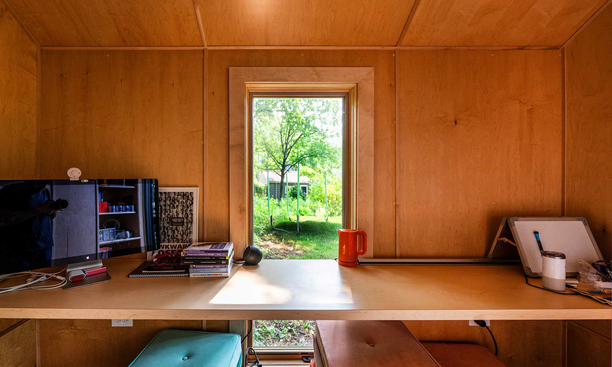 maple walls with builtin desk outdoor home office bunkie shed from interior looking out window over desk