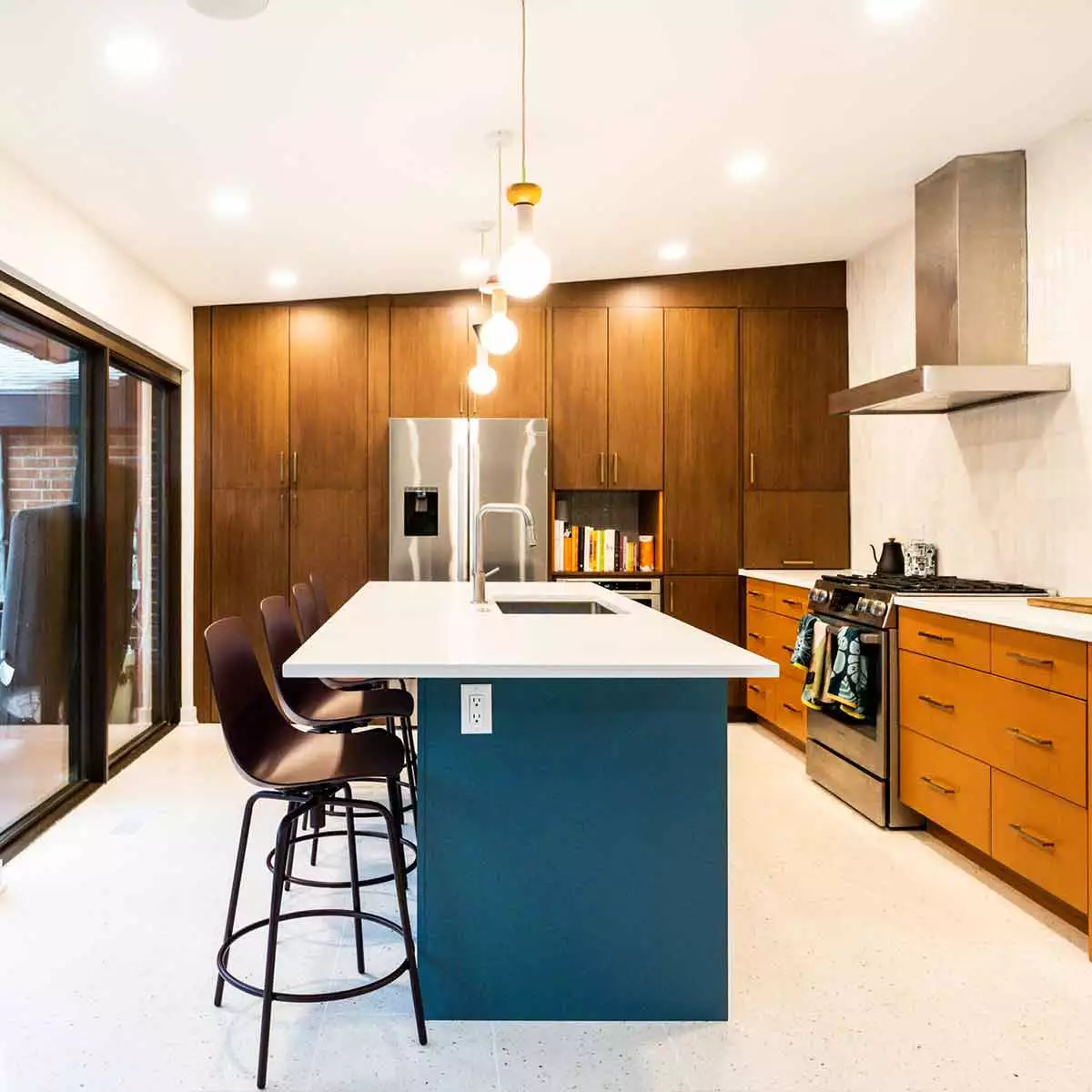 Mid century modern luxury kitchen remodel in Riverside IL by LivCo with blue island orange perimeter cabinets walnut tall cabinets and terrazzo flooring