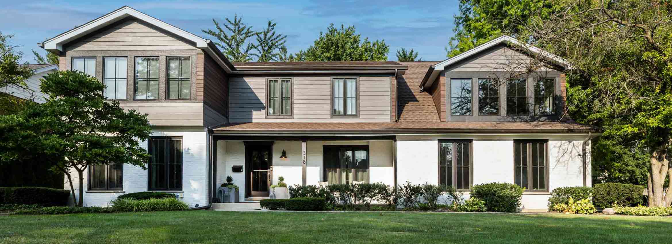 Exterior view of modern second story addition in Hinsdale, illinois with grey siding and black windows