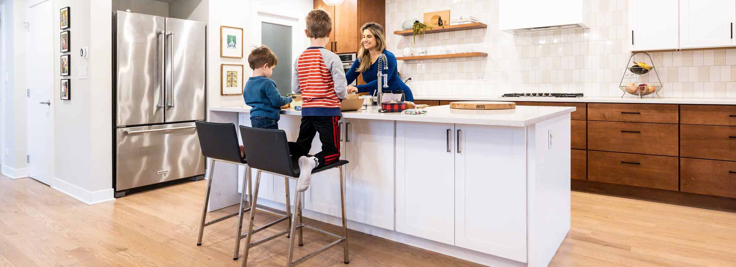 mother and sons gathered around kitchen island in a luxury remodel in Western springs illinois