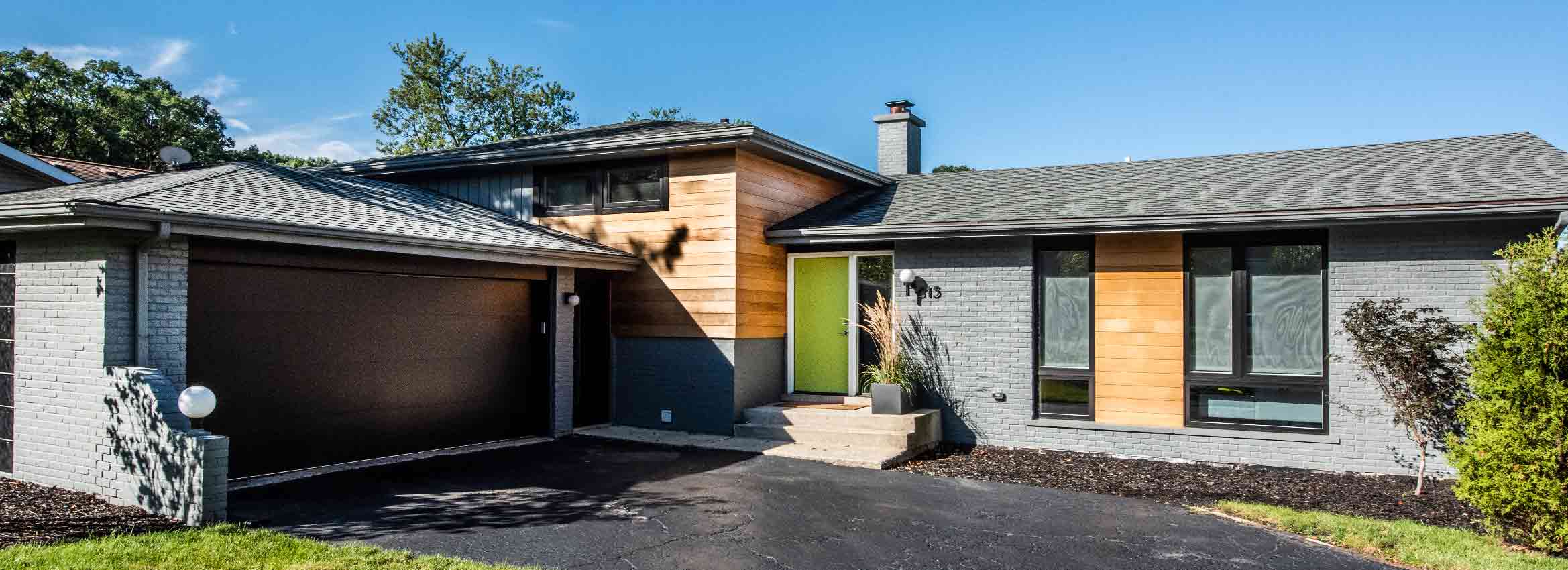 exterior mid century modern split level remodel with cedar siding and grey brick