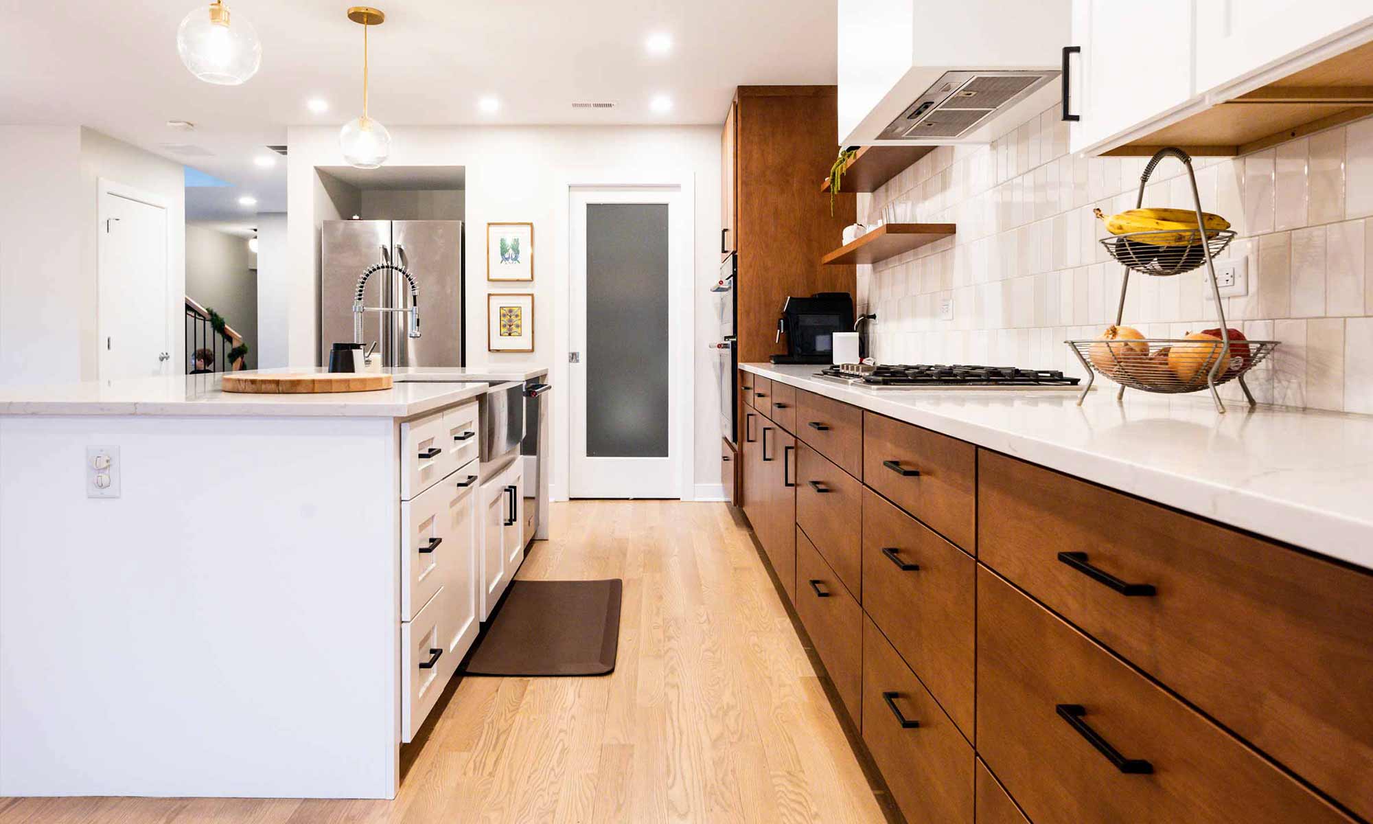view towards pantry of modern kitchen remodel with wood and white cabinets in western springs