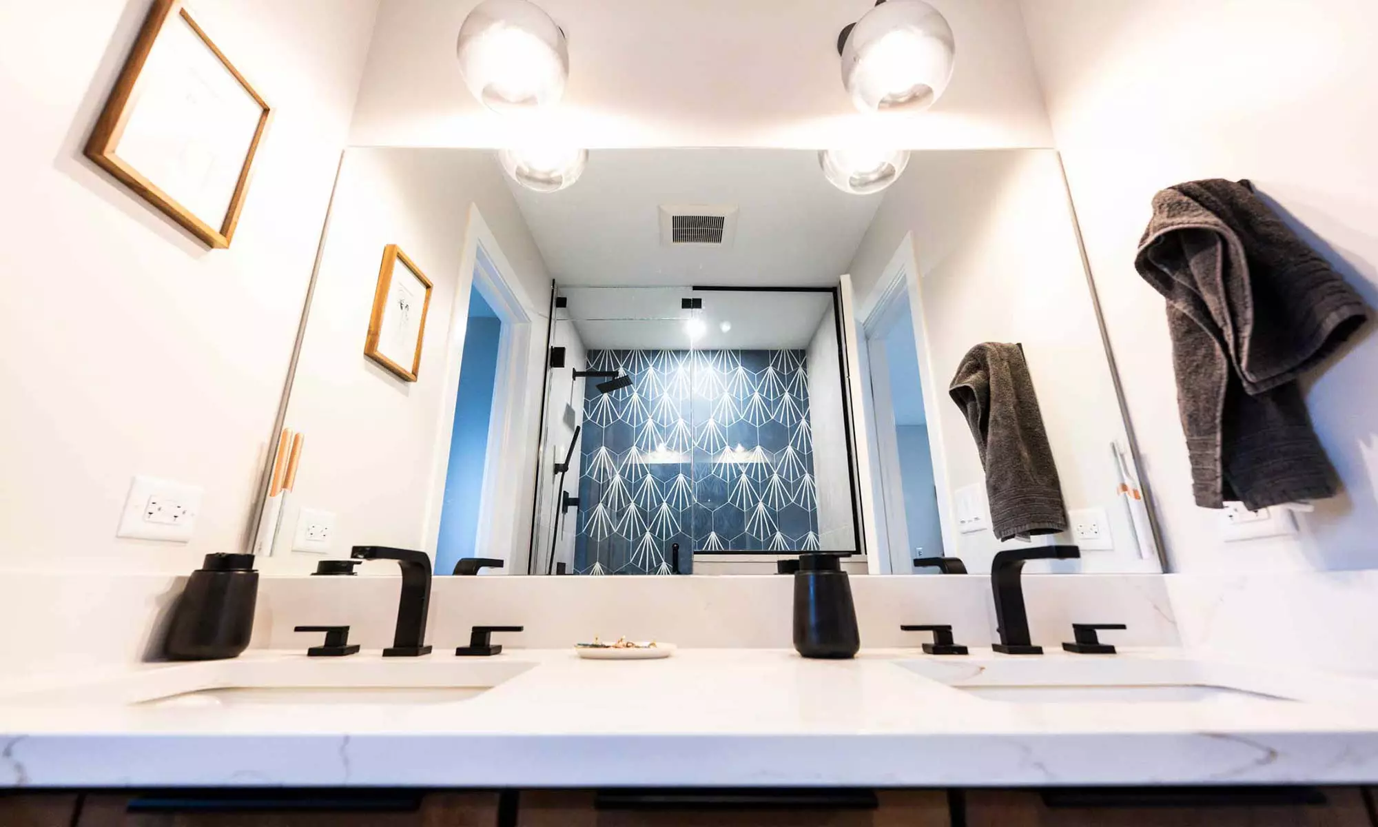 double vanity mirror with black plumbing fixtures and blue tile refection in western springs luxury remodel and addition