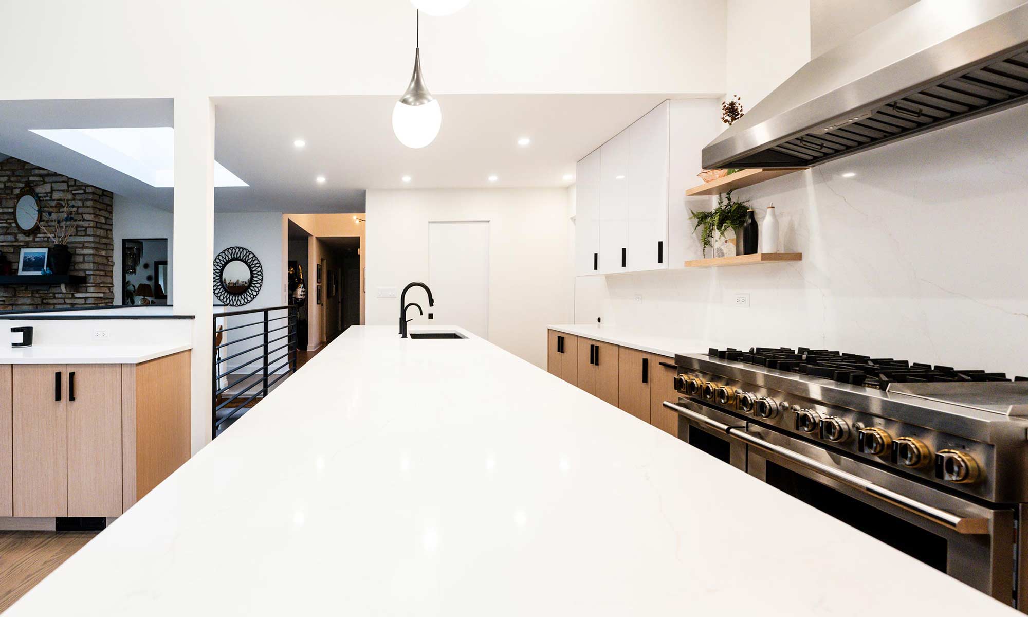 Indian Head Park luxury kithcen remodel by LivCo featuring wood, black, and gloss white modern cabinetry view of large island