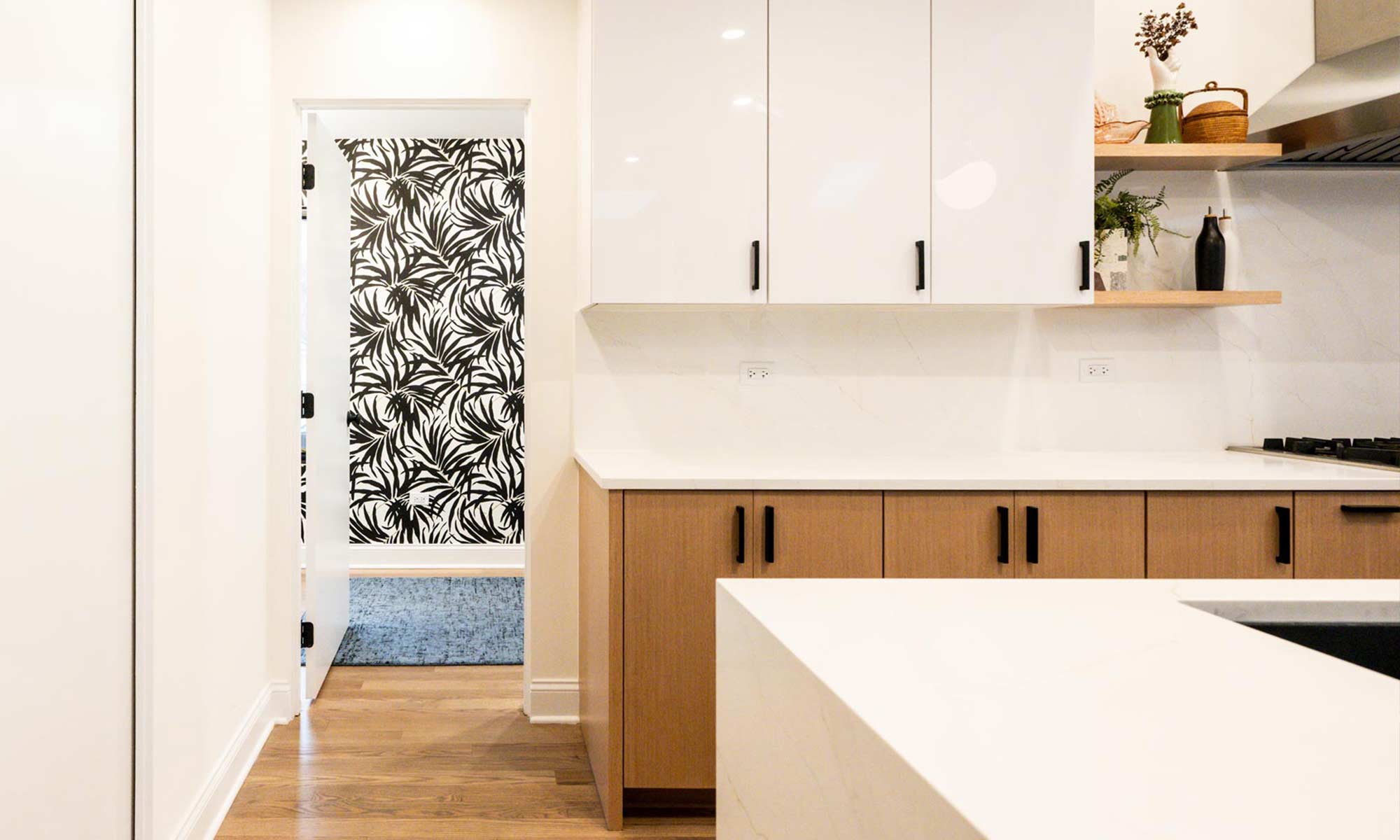 Indian Head Park luxury kithcen remodel by LivCo featuring wood, black, and gloss white modern cabinetry with view towards textured wallpaper in office and laundry