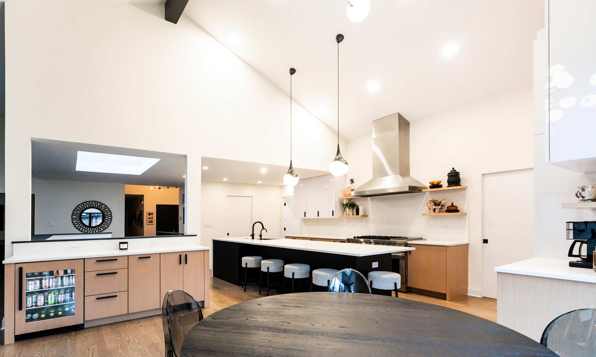 Indian Head Park luxury kithcen remodel by LivCo featuring wood, black, and gloss white modern cabinetry view from breakfast room with built-in bar