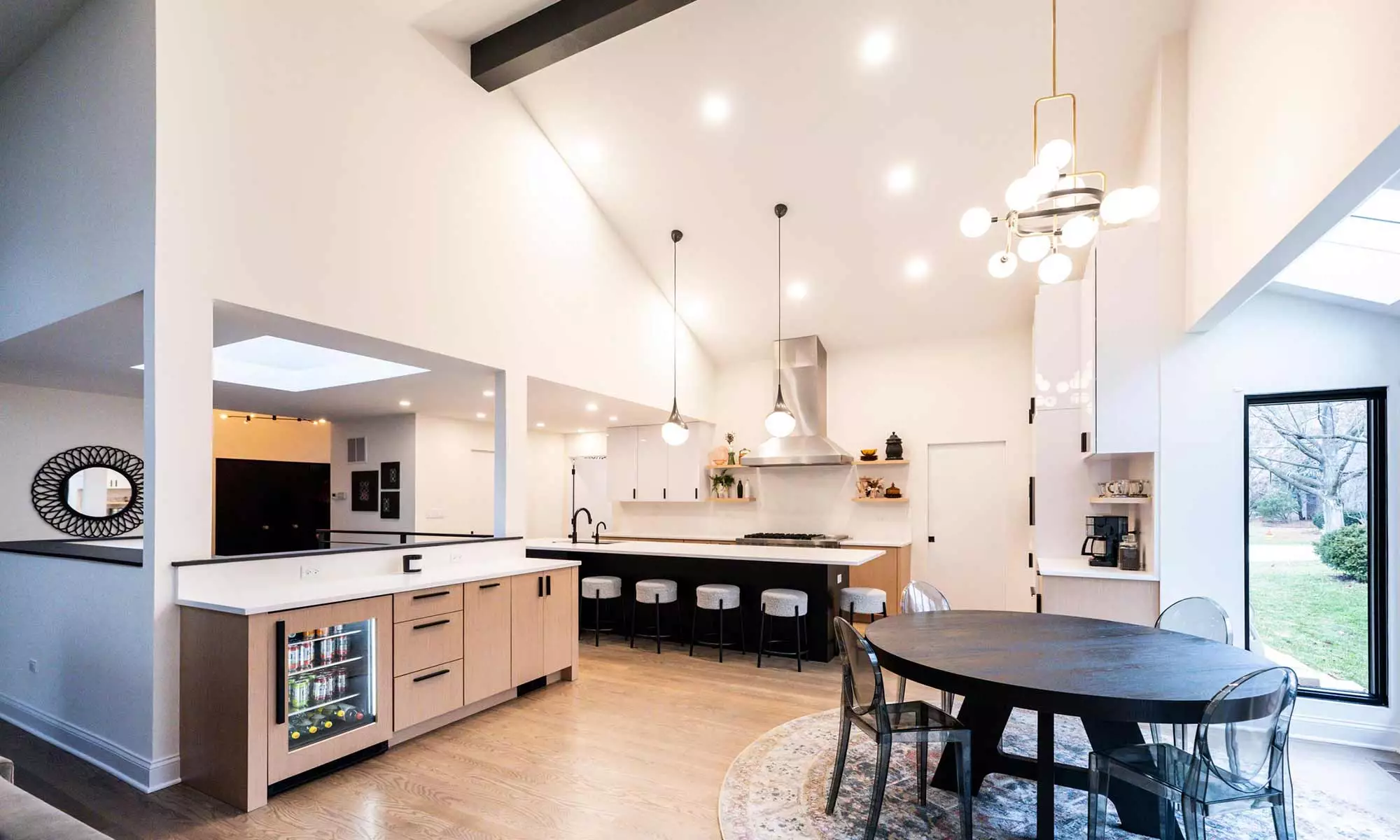 Indian Head Park luxury kithcen remodel by LivCo featuring wood, black, and gloss white modern cabinetry with view of breakfast room and built-in bar cabinetry