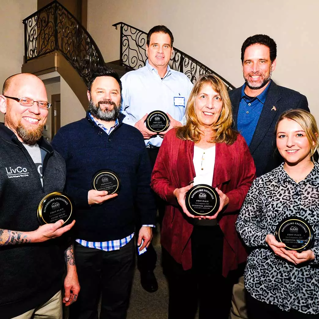 LivCo design and consriction team posing with numerous NARI awards for remodeling excellence