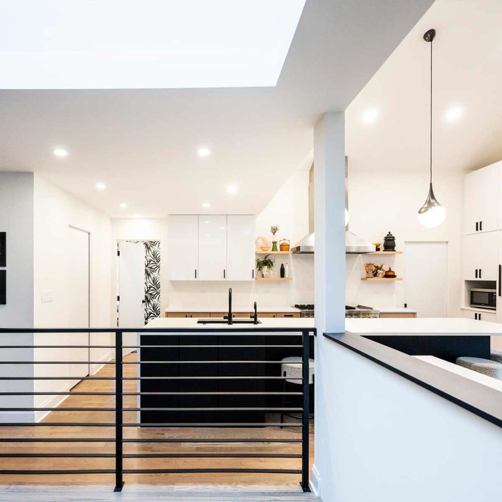 modern kitchen remodel in indian head park illinois with black cabinets and metal rail at stair to basement