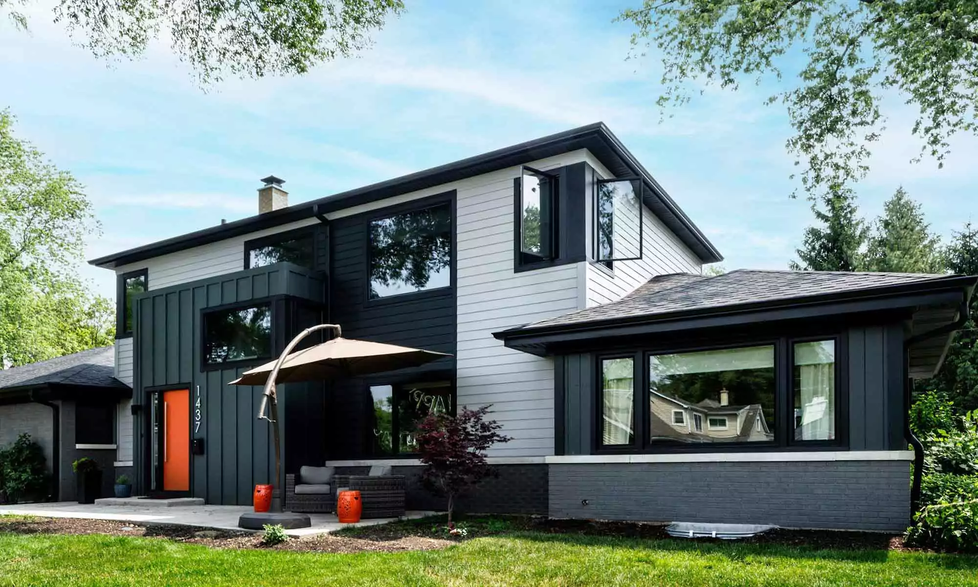 exterior view of modern luxury second story addition with grey siding and black windows