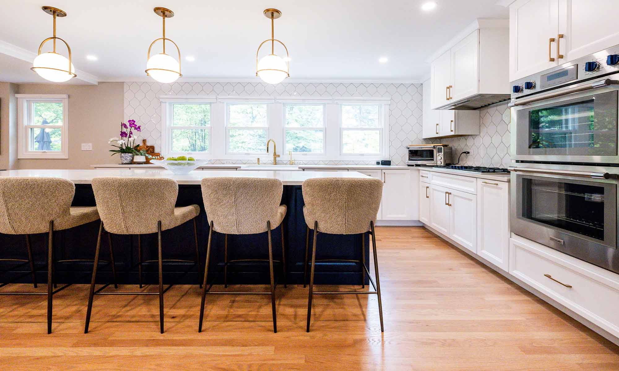 A kitchen with white cabinets and chairs