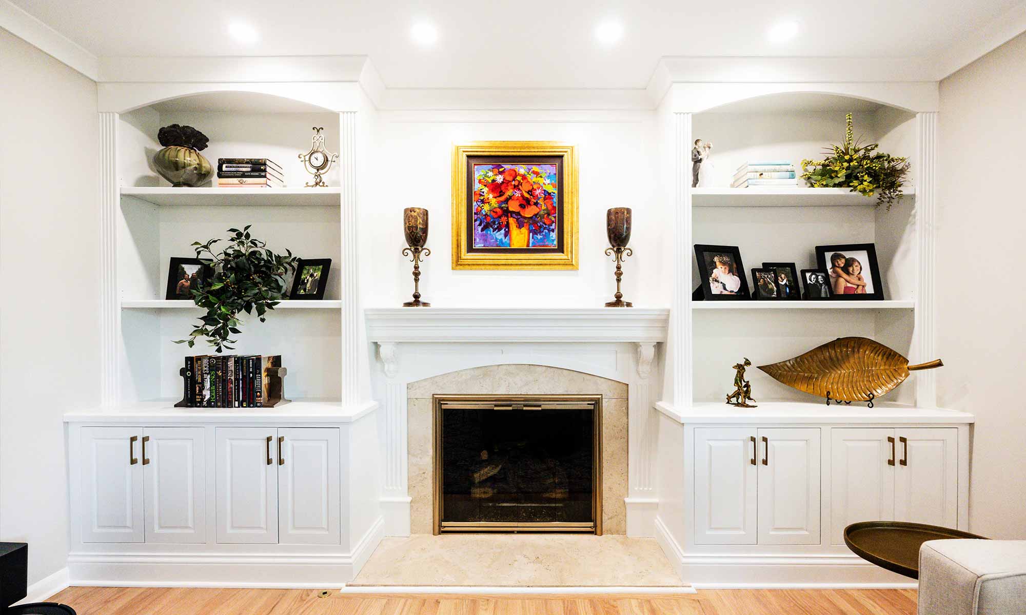 A fireplace with shelves and a painting on the wall