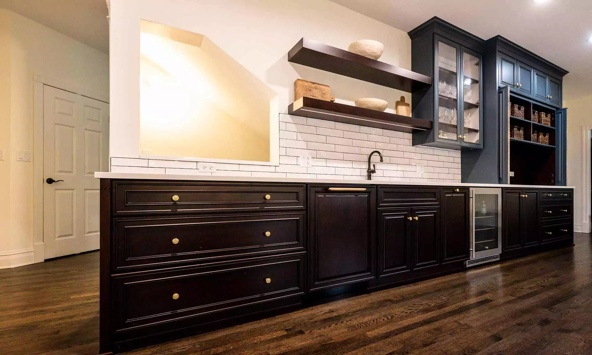 brown and slate blue kitchen bar cabinets with beverage fridge and open shelves