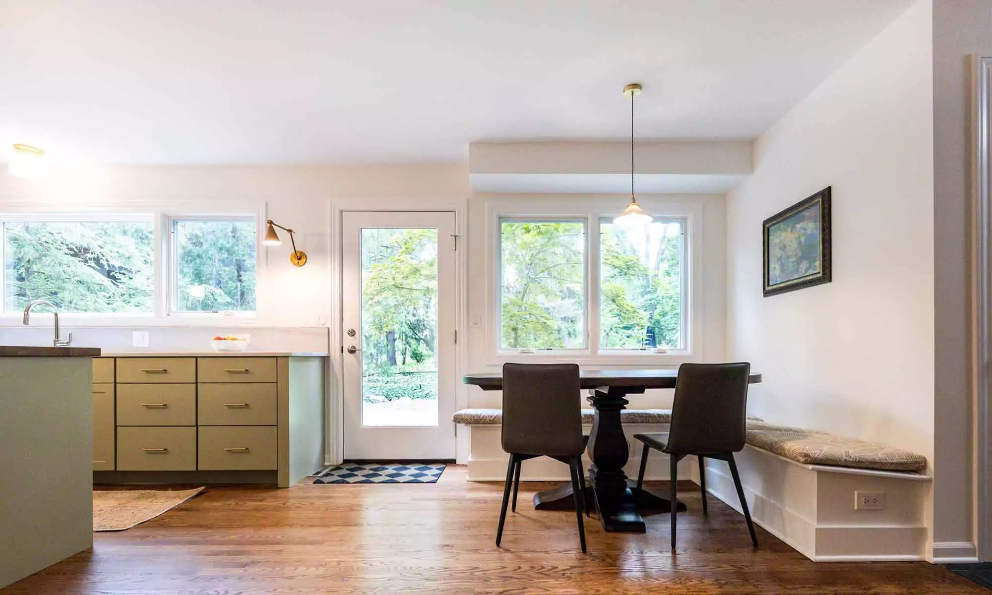 looking towards backyard through windows and door in luxury kitchen remodel with green cabinets