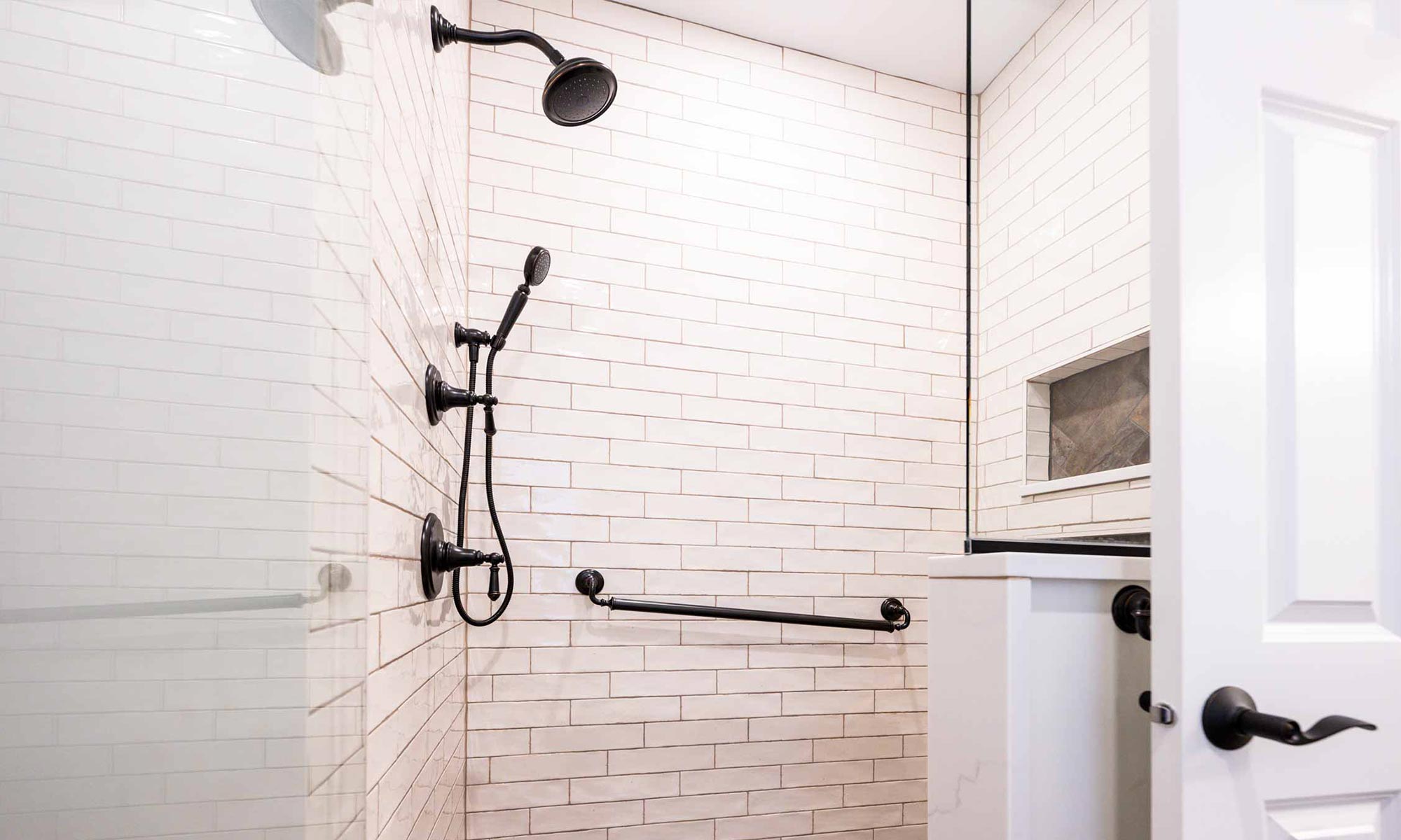 white subway tile shower with black fixtures and ADA grab bars