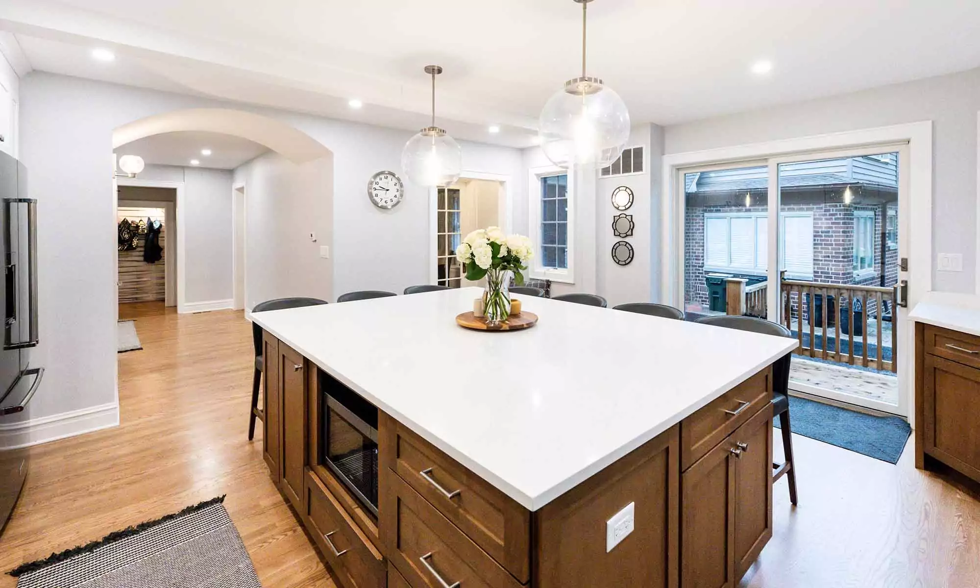large kitchen island in luxury remodel with eight windows and white quartz countertops