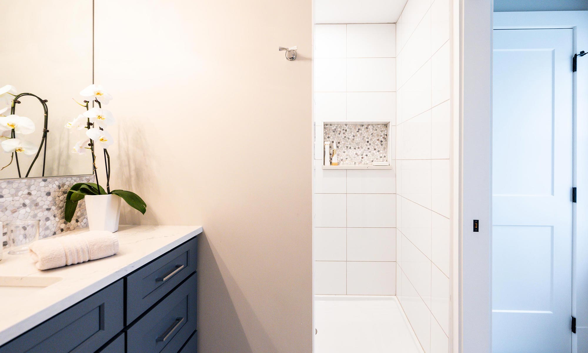 hall bath remodel with blue vanity cabinets and walk-in shower