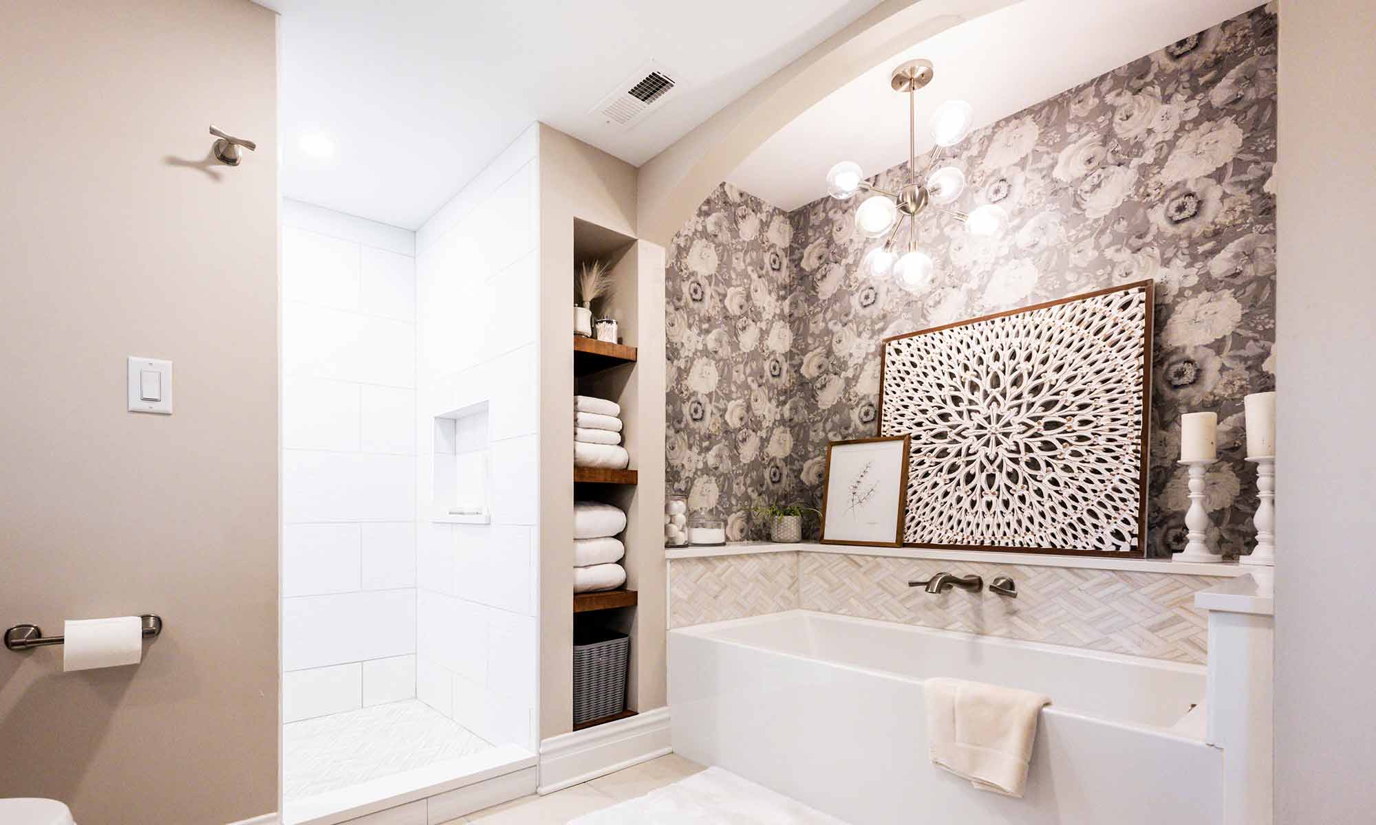 soaking tub with tile and quartz surround and open wood linen shelves and white shower tile