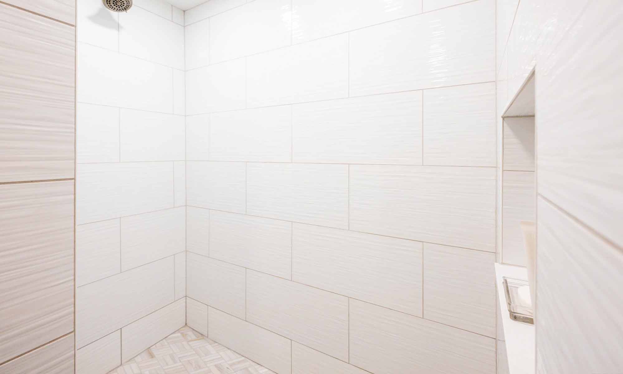 closeup of white shower tile in brick pattern